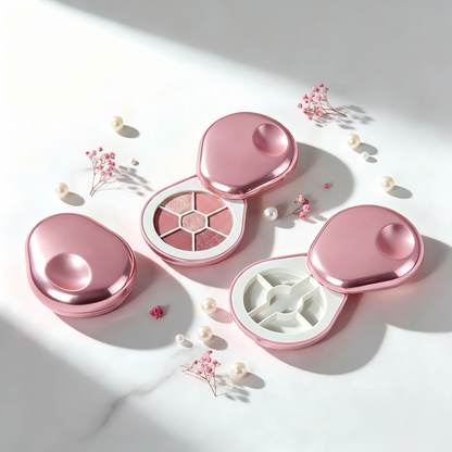 Oval rose pink metallic eyeshadow cases flat lay on marble with dried flowers