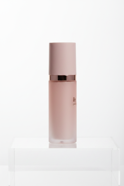 Side profile of blush pink airless pump bottle on white background