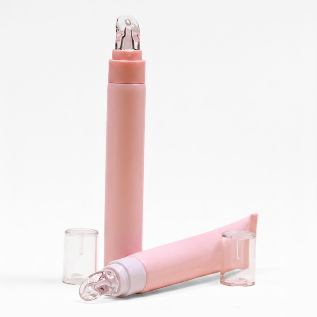 Pink eye cream roller pen and squeeze tube set white background